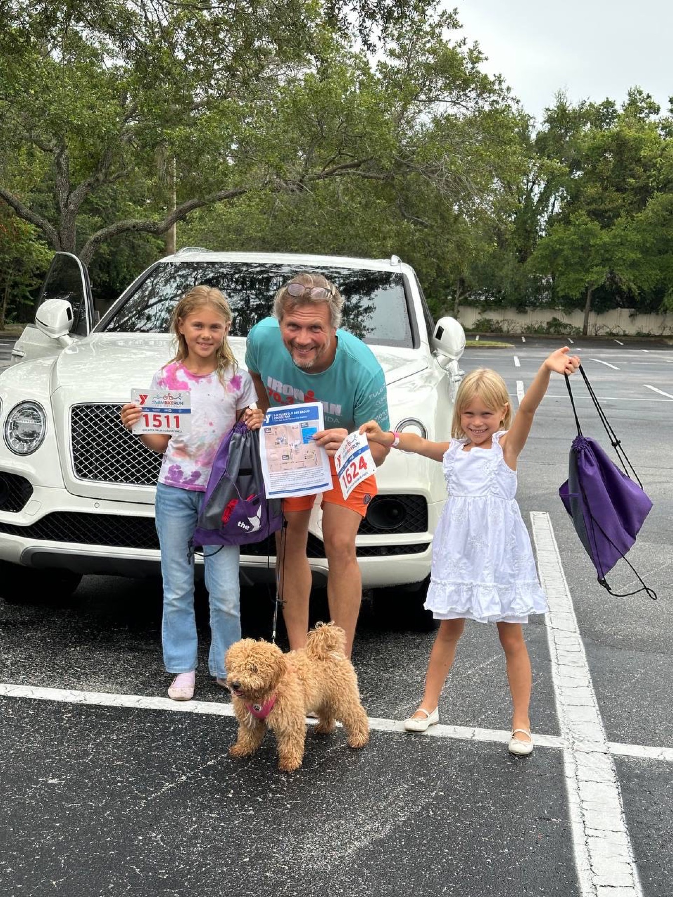 Dmitry with his daughters and dog in front of the Bentley after a family race